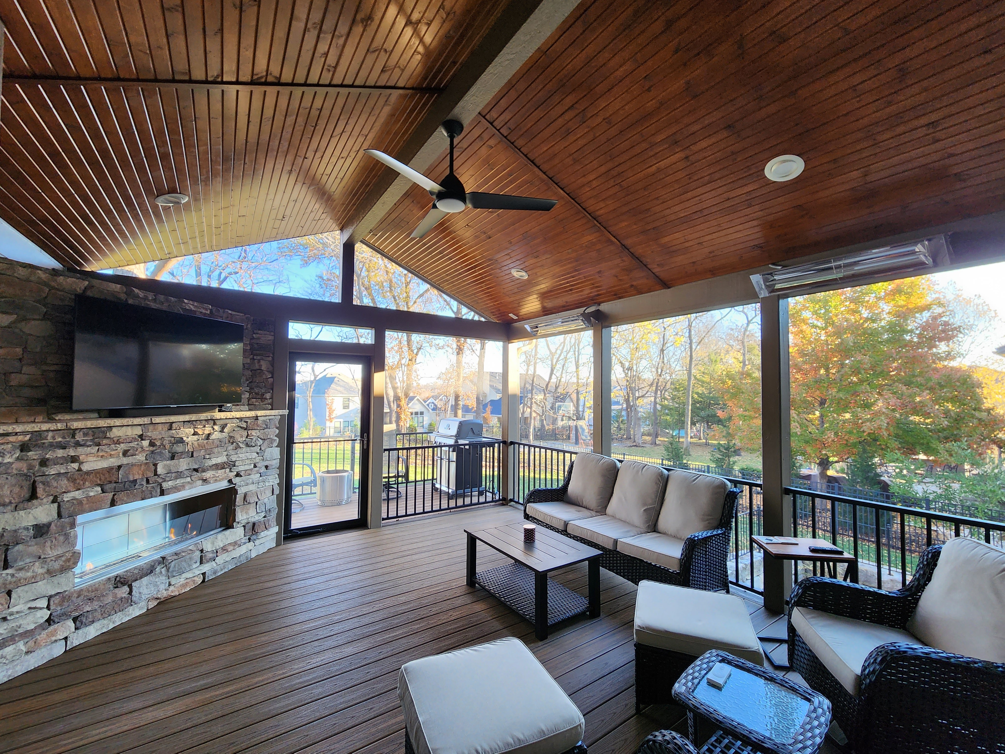 Rustic covered deck with wood panel ceiling