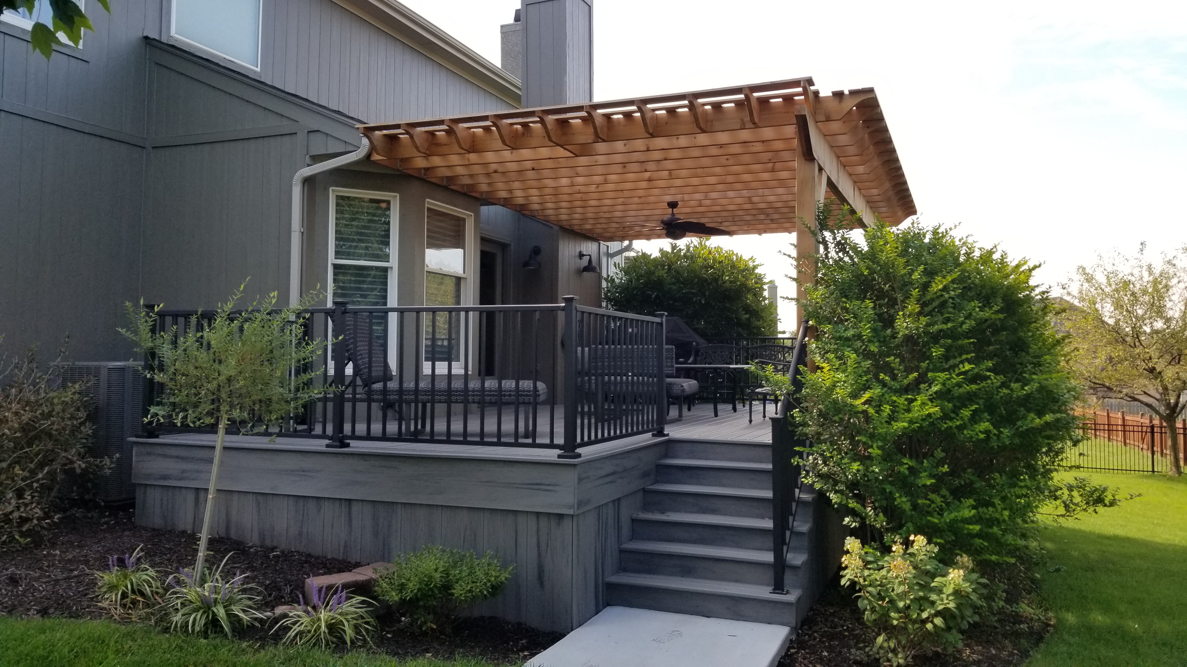 Grey composite deck with an attached pergola